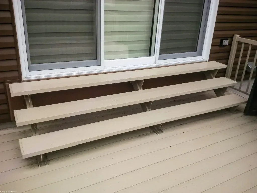 Beige deck stairs by sliding windows