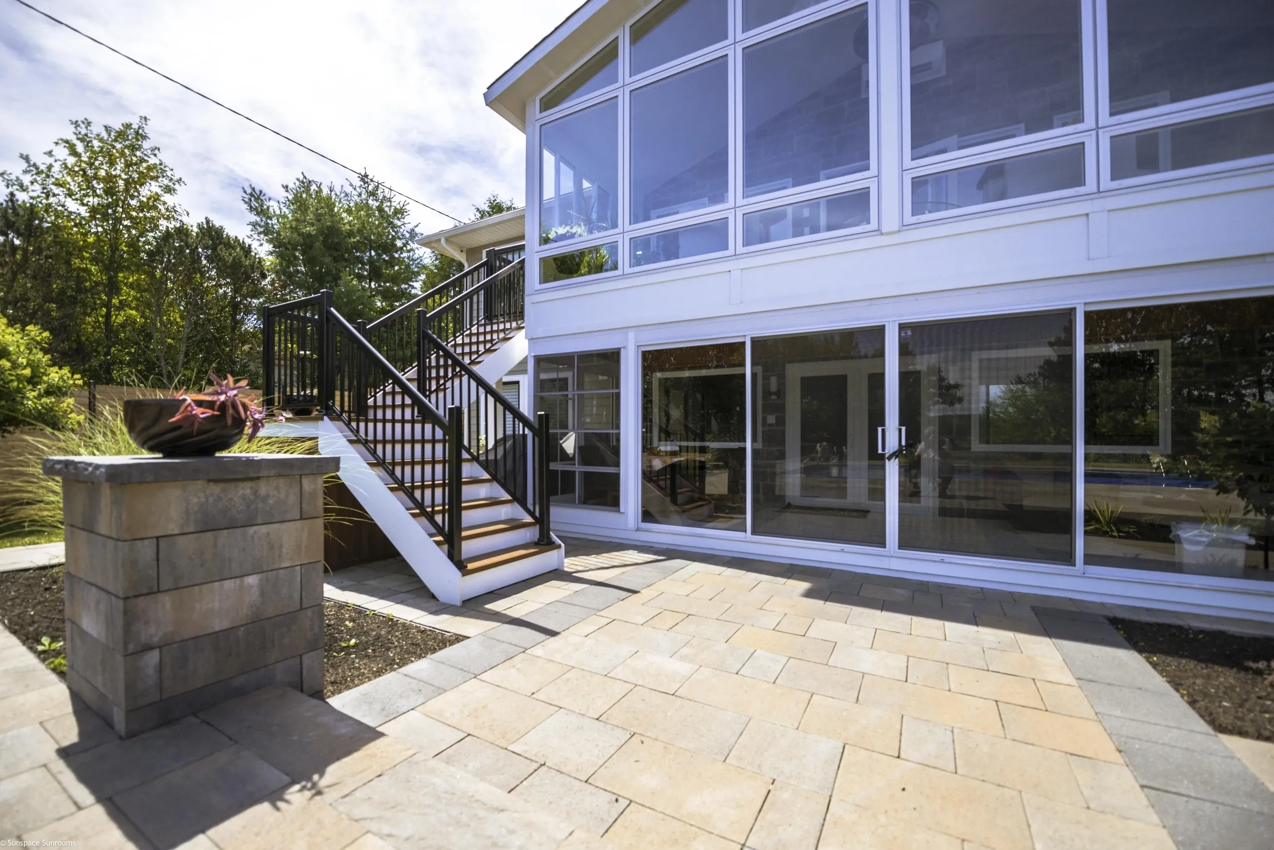Sunlit patio with staircase and windows