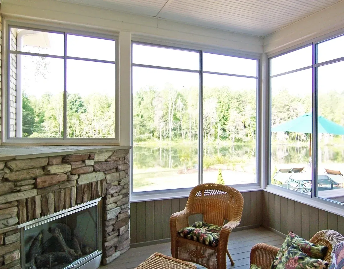 Bright sunroom with large windows and chairs