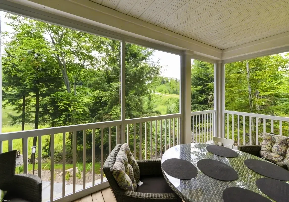 Screened porch overlooking lush green landscape